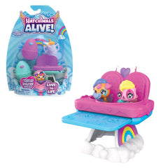 Hatchimals Alive playset features a pink and blue highchair with a small figure wearing a purple hat and holding a pink heart