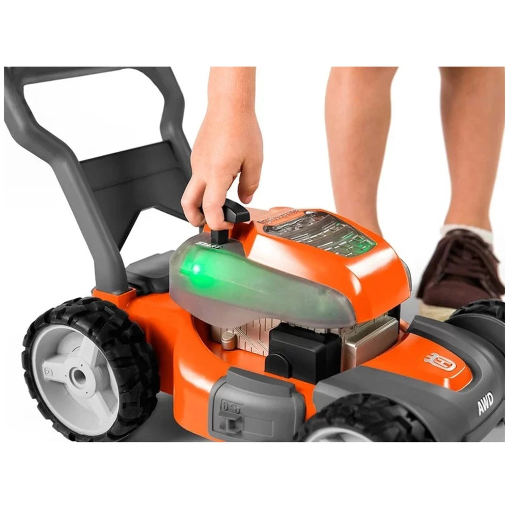Husqvarna toy lawn mower features an orange body, black wheels, and a green light, designed for pretend professions and role 