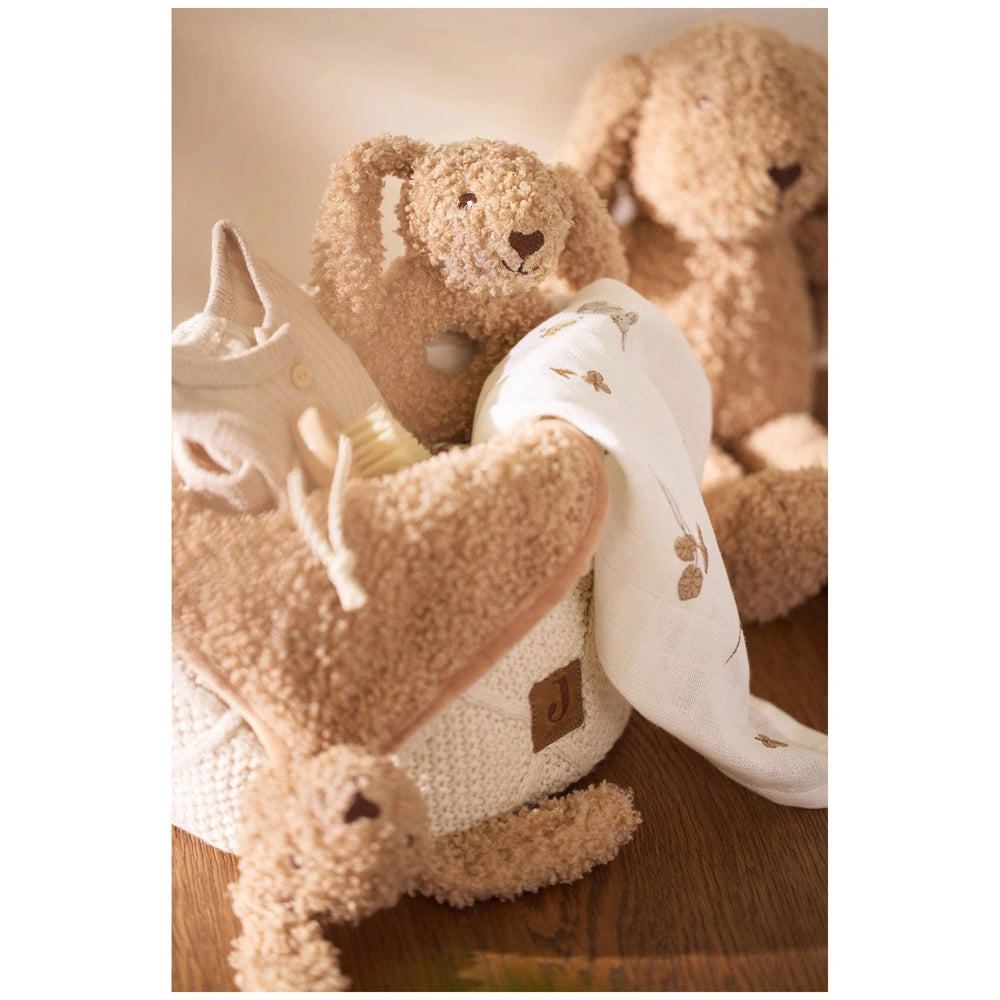 Jollein pacifier cloth bunny stuffed animals in light brown plush, arranged in a close-up on a wooden surface.