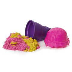 Kinetic Sand Ice Cream Cone Container features a glossy purple cup filled with yellow and pink sand on a white surface.