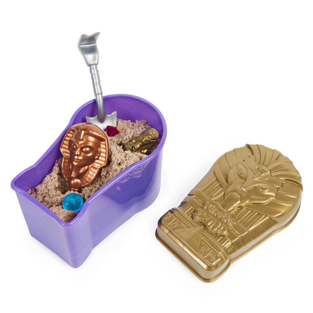 Kinetic Sand Mummy Tomb features a purple container filled with sand and a shiny golden amulet with hieroglyphic designs.