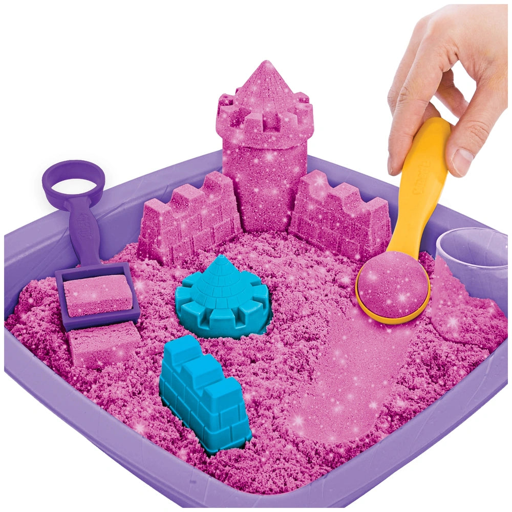 Kinetic Sand Shimmer Sparkle Sandcastle Set features a pink castle, blue ramp, and purple base in a colorful sandbox.