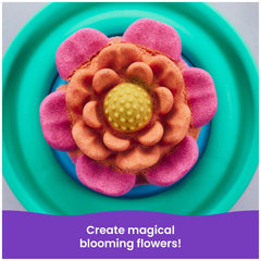 Kinetic Sand Squish Blossom features a pink and orange flower on a blue plate with a yellow center, promoting magical flower