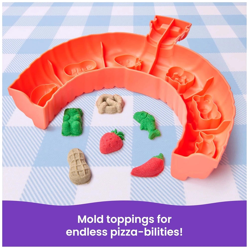 Kinetic Sand Squish Pizza features colorful plastic food items arranged on a blue and white checkered tablecloth.