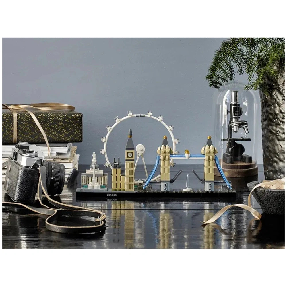 LEGO Architecture London set displayed on a dark surface, showcasing Big Ben, Tower Bridge, and the London Eye, with a vintage camera and decorative items in the background.