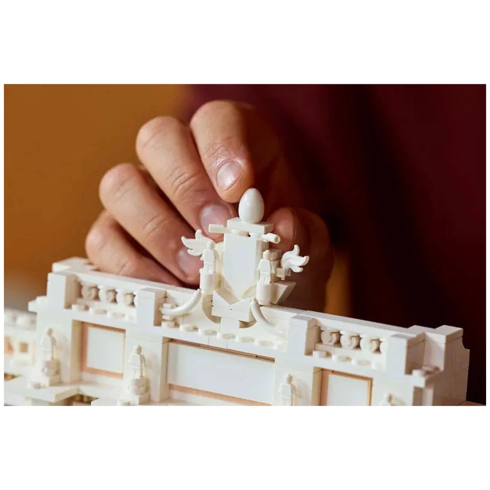Lego Architecture Trevi Fountain construction set held in a hand, showcasing its smooth white plastic design and textured sur