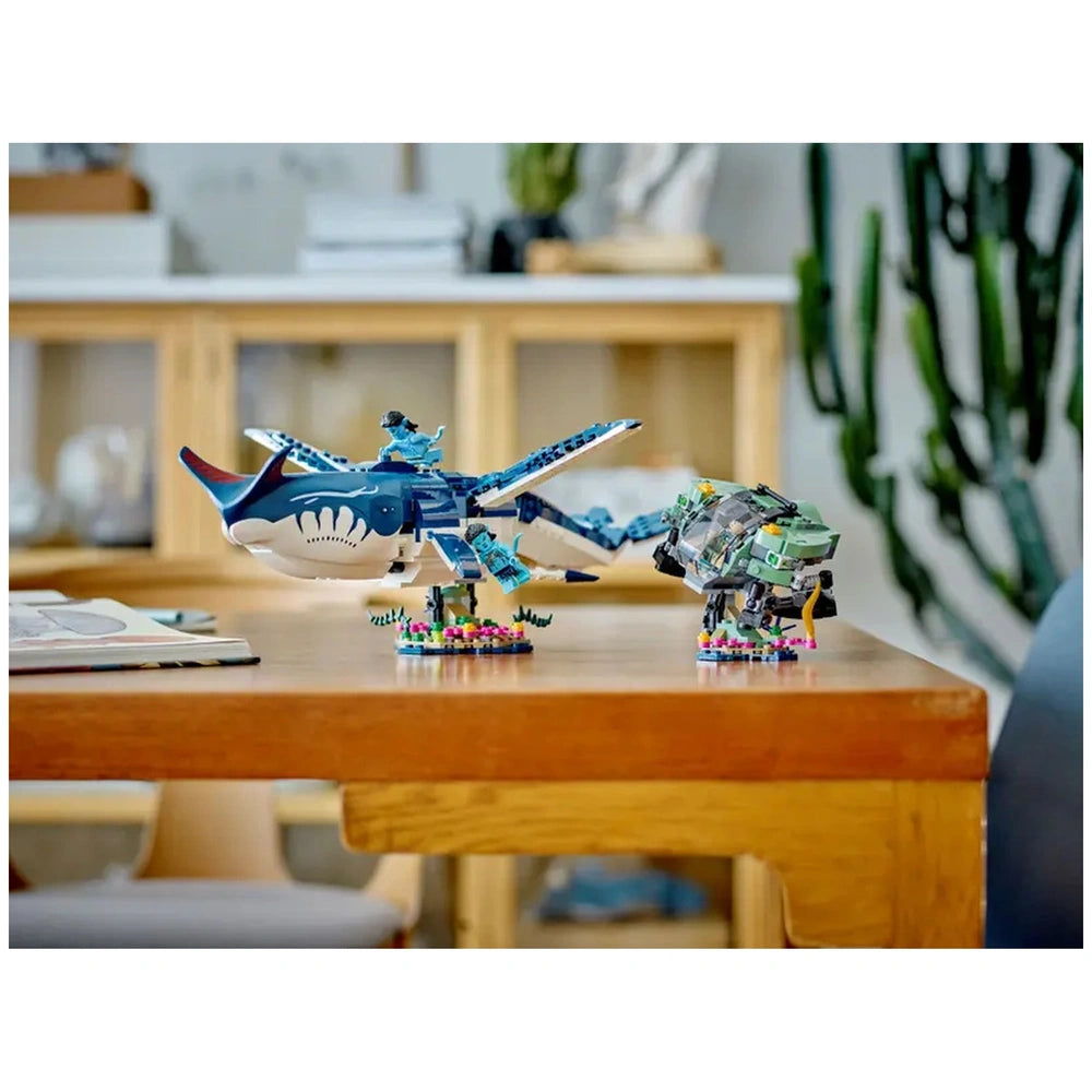 LEGO Avatar Payakan the Tulkun and Crabsuit construction set displayed on a wooden table, featuring detailed blue tulkun and crabsuit figures with vibrant seabed elements.