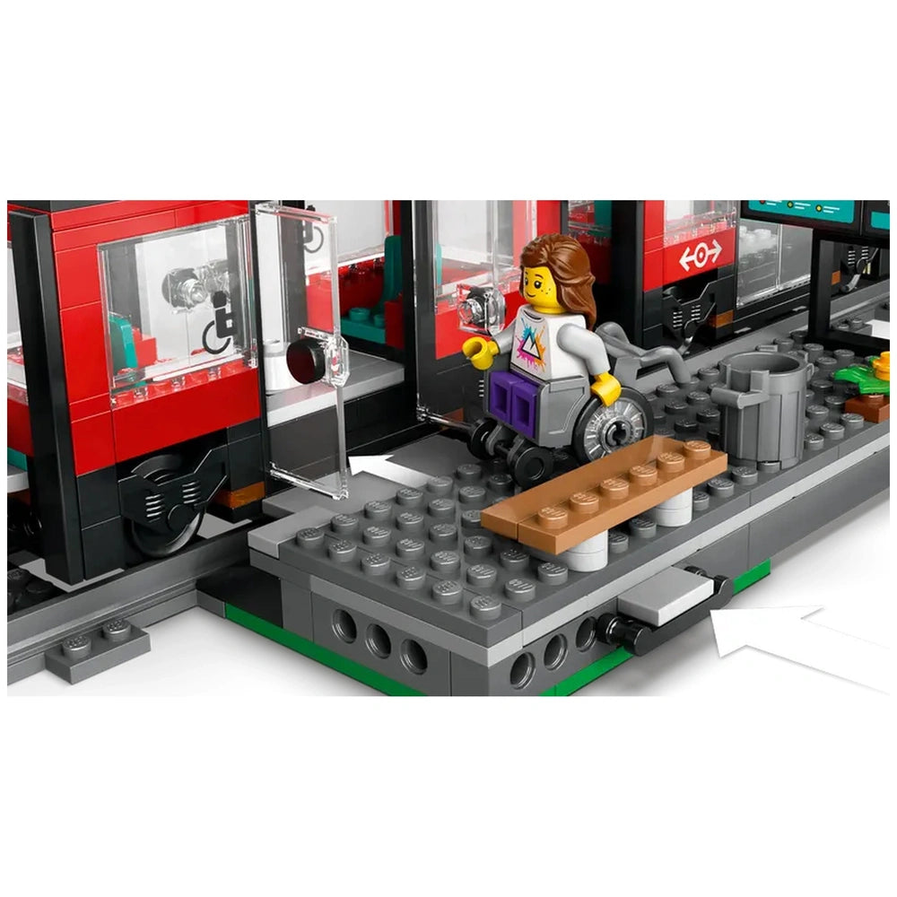 A LEGO® minifigure in a wheelchair approaches a red streetcar with open doors, set on a detailed gray platform with a bench and trash can.