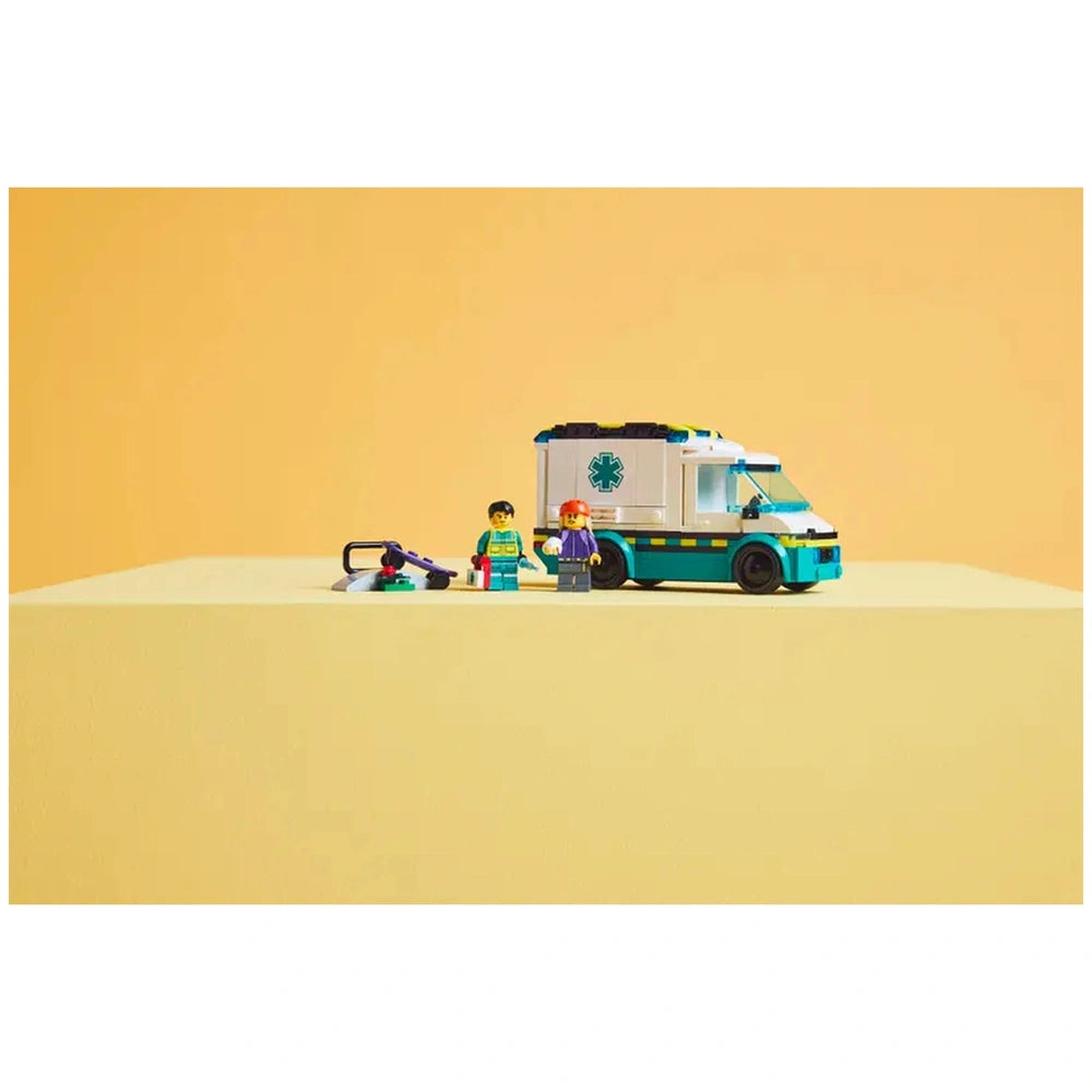 LEGO® City Emergency Ambulance set featuring a toy ambulance with an emblem, two minifigures in medical outfits, and accessories like a stretcher and skateboard on a yellow background.