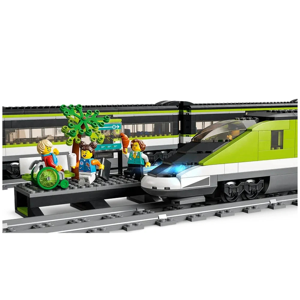 Colorful LEGO City Express Passenger Train set features a sleek green bullet train at a station with minifigures, including a child in a wheelchair and trees.