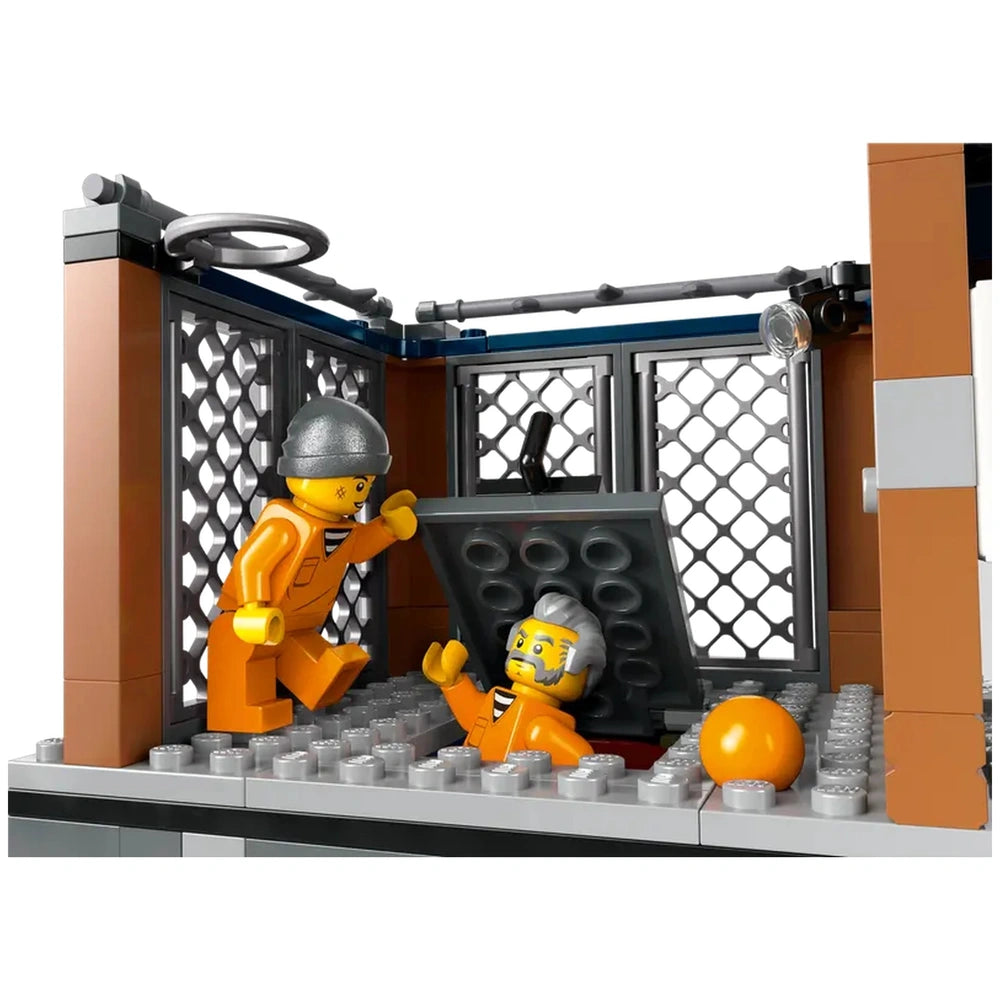Two LEGO® figures in orange prison jumpsuits inside a jail cell; one attempts to escape through a hidden hatch.