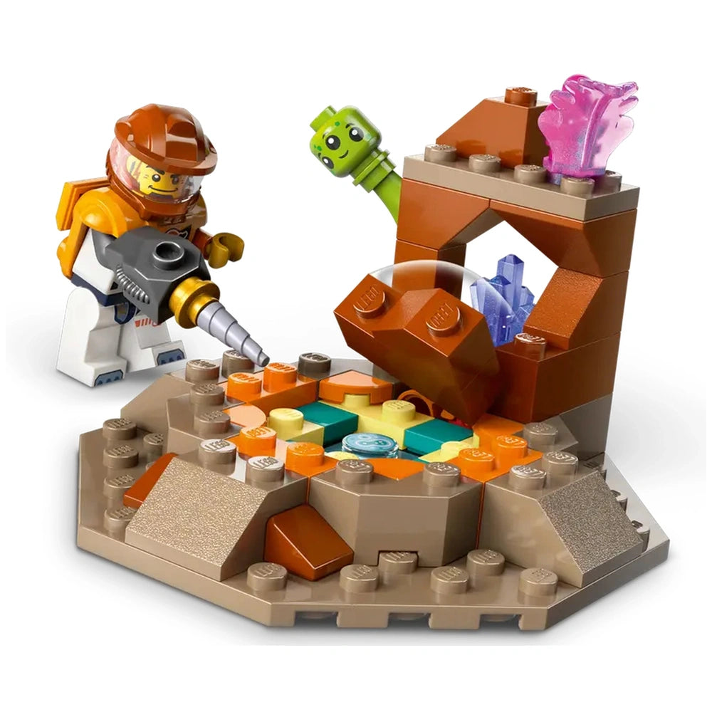 A LEGO® astronaut uses a drill on a colorful alien rock formation, featuring orange, green, and blue elements with crystals.