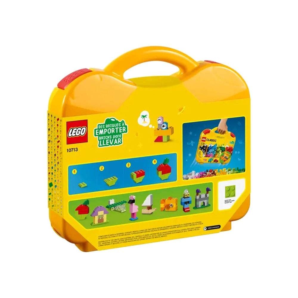 Bright yellow LEGO® Classic Creative Suitcase with a handle, featuring images of colorful building creations like houses, trees, and vehicles on the sides.