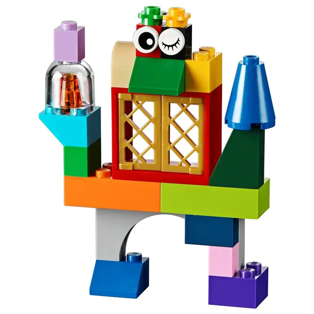 Colorful LEGO creation with eyes, windows, and a blue cone-shaped roof, featuring various shapes and bright pieces.