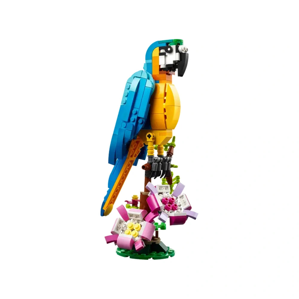 Colorful LEGO® Creator 3in1 Exotic Parrot model in vibrant blue and yellow, perched on a tree branch with pink flowers.