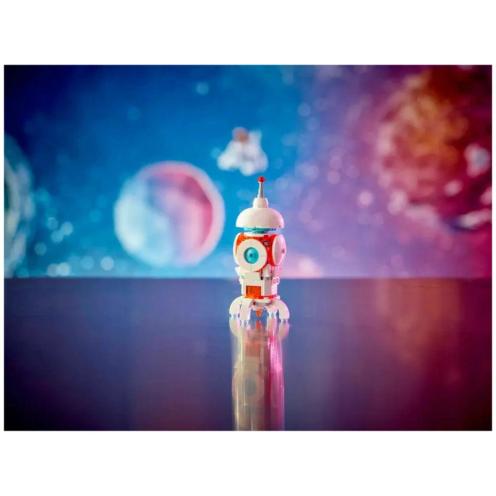 LEGO Creator 3in1 Space Robot construction set on a glossy surface, featuring a colorful robot with a blue eye and a white dome against a vibrant space backdrop.