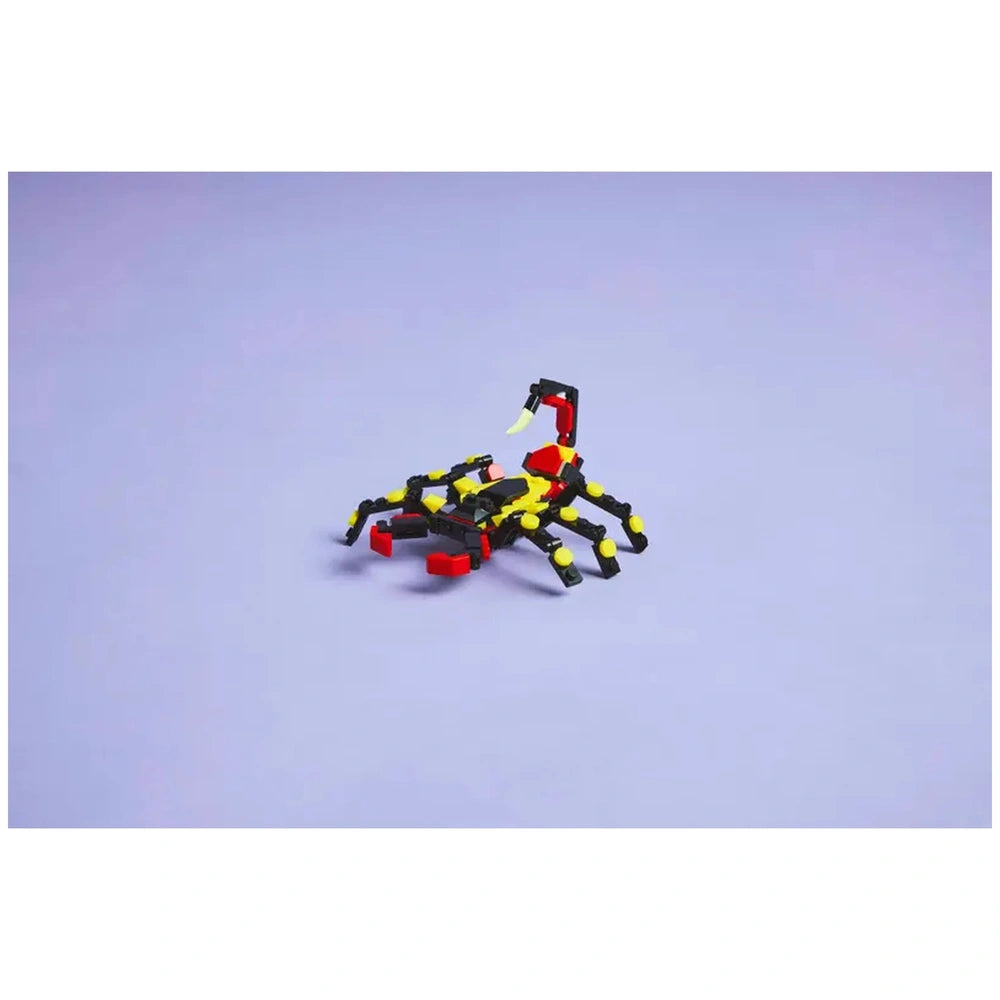 Posable LEGO spider figure with articulated legs, bright yellow and black colors, and red accents, set on a light purple background.