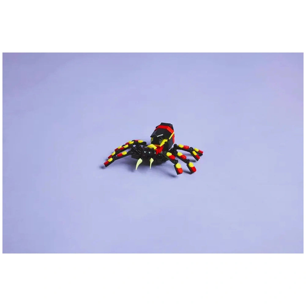 Posable LEGO Creator spider figure with eight articulated legs, bright red and yellow accents, and striking large teeth, set against a light purple background.