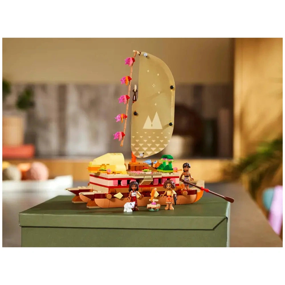 LEGO® Disney Moana's Adventure Canoe set featuring a vibrant double-hulled canoe with a colorful sail, surrounded by Moana and friends, on a green box.