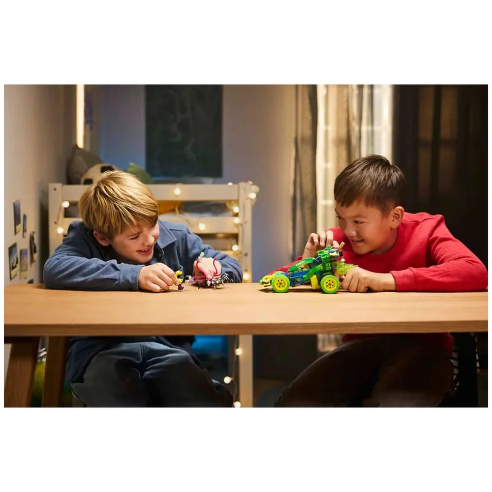 Two boys joyfully playing with LEGO DREAMZzz toys on a wooden table, featuring a colorful Z-Blob Action Race Car and a small figure.