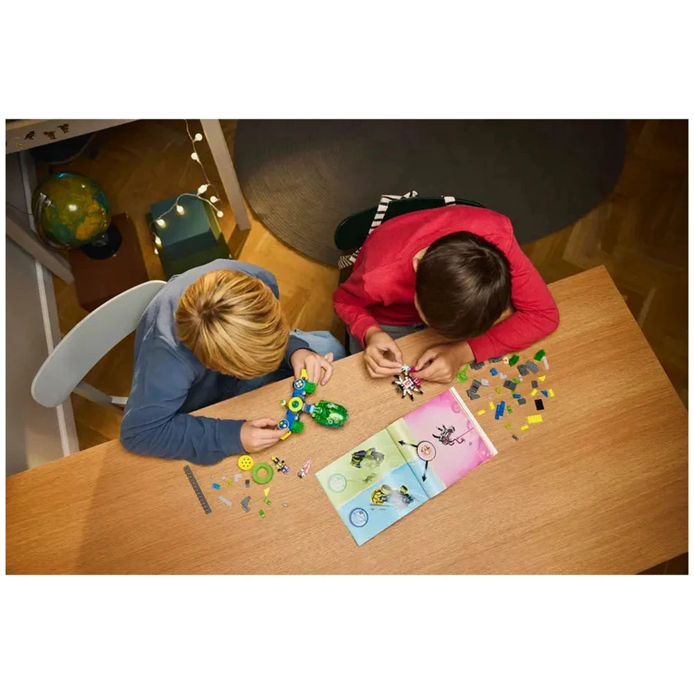 Two children building with LEGO® DREAMZzz™ Mateo and the Z-Blob Action Race Car set on a wooden table, surrounded by colorful pieces and an instruction booklet.