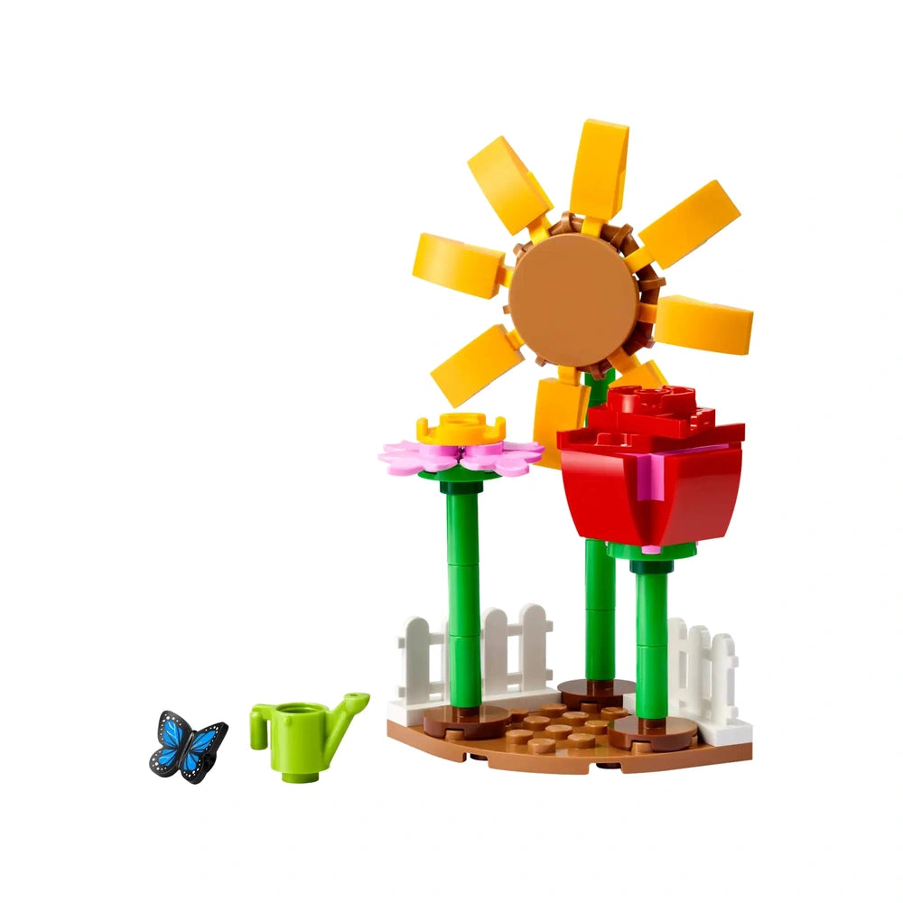 Colorful Lego Friends Flower Garden set featuring a sunflower, pink flower, red rose, green watering can, and a butterfly.