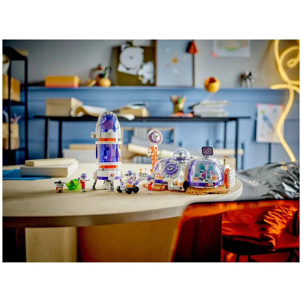 LEGO® Friends Mars Space Base set featuring a rocket, rover, and three mini-dolls in a playful space exploration scene on a table.