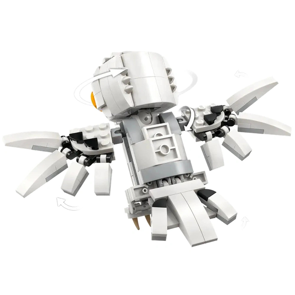 Posable LEGO figure of Hedwig, the snowy owl from Harry Potter, with movable wings, head, and tail, set against a white background.