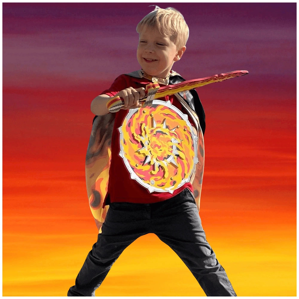 Young boy in a red costume with a yellow and red shield holds a Liontouch Flame Sword against a vibrant orange and purple bac