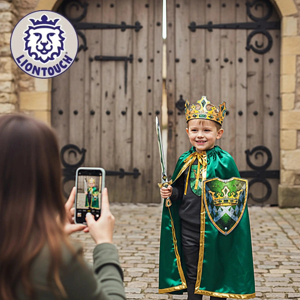 Liontouch Kingmaker Sword held by a child in a green and gold costume and crown, standing by a wooden door on brick pavement.