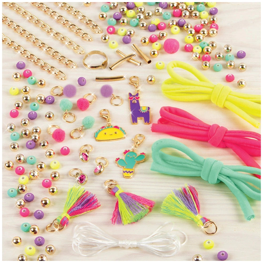 Neo-Brite Chains and Charms set featuring various gold-colored accessories like chains, beads, and pom poms in a close-up lay