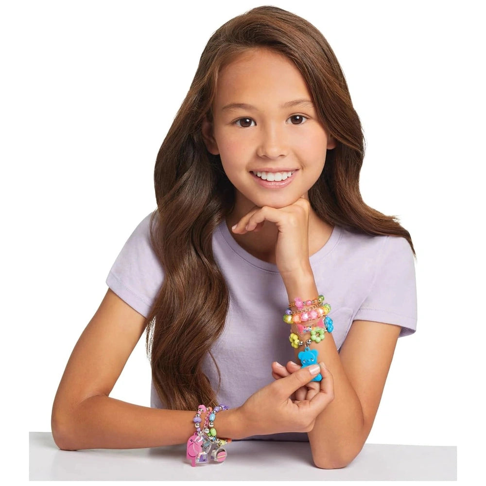 Pop Shake Twist Bracelet Set worn by a smiling girl in a purple t-shirt, featuring colorful beads on her left wrist.