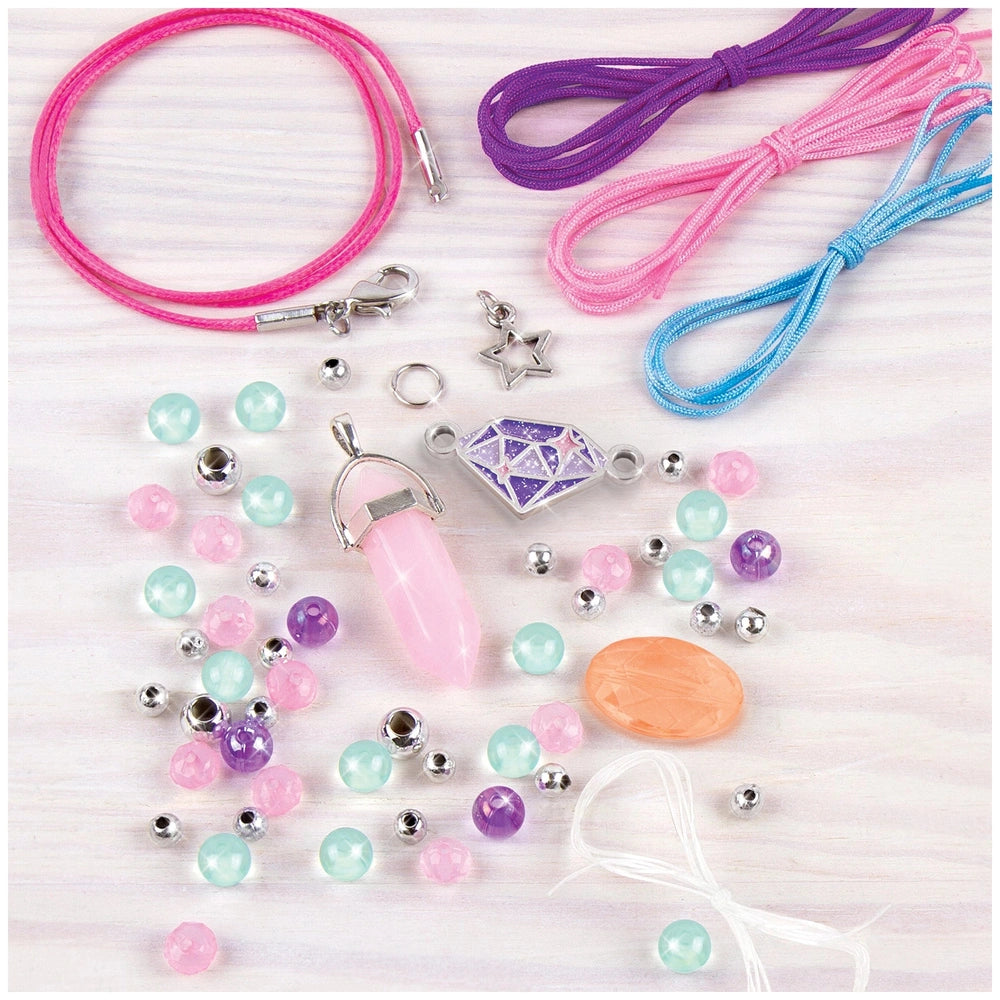 Positive Gems Jewelry set featuring colorful nail polish bottles, earrings, a bracelet, and hair tie on a light wooden table.