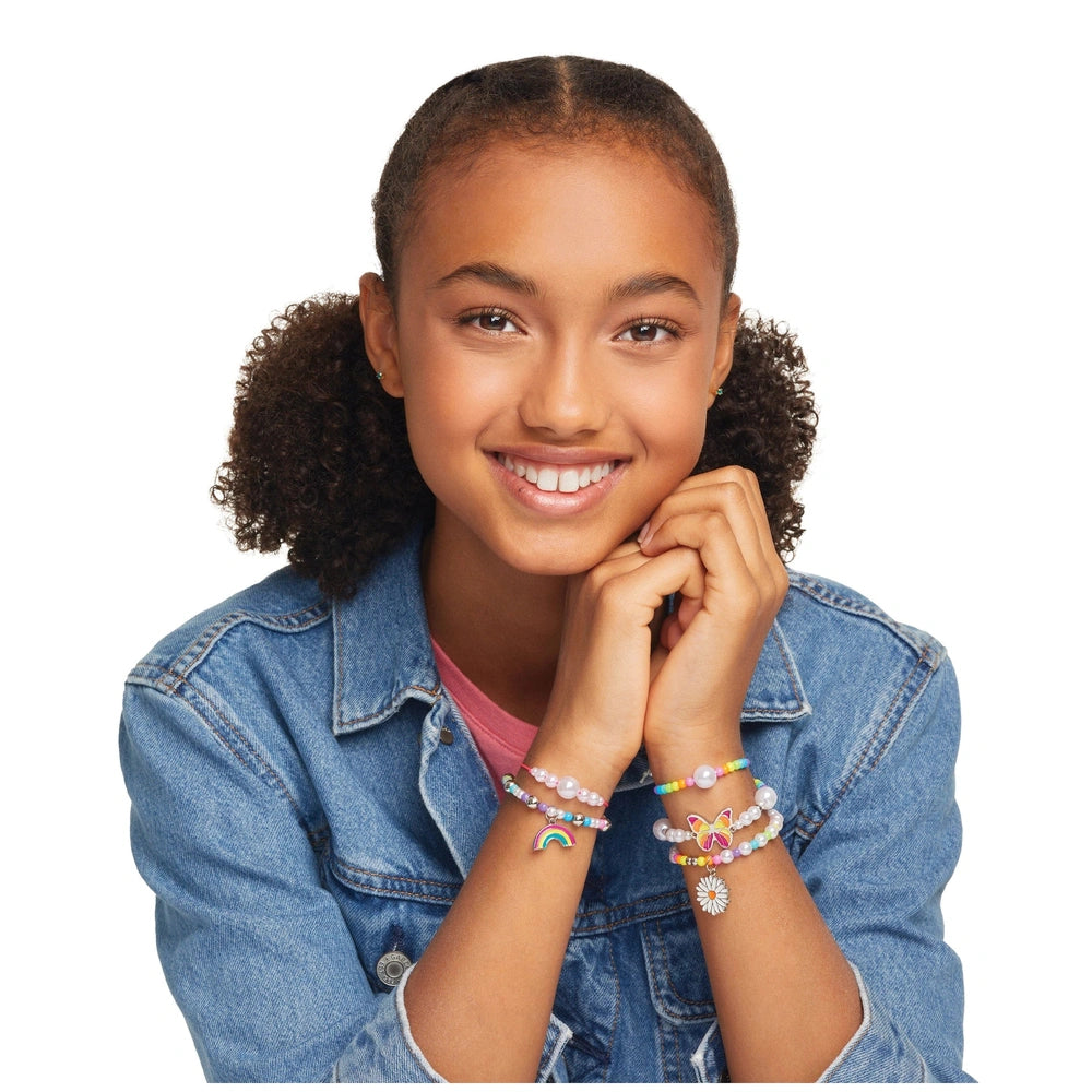 Rainbow Treasure Bracelets showcased on a smiling girl in a denim jacket and pink top, wearing multicolored bracelets.