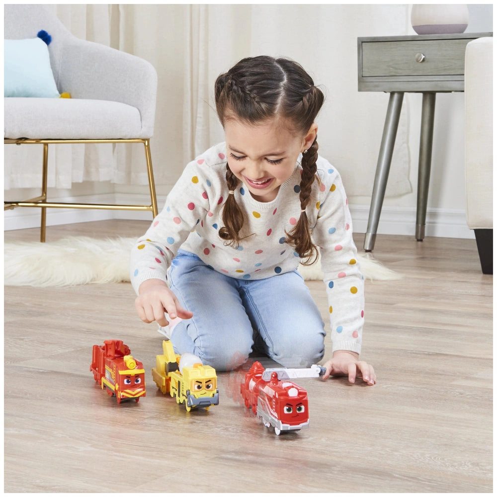 Mighty Express Motorized Train set being played with by a smiling girl in a polka dot top on a smooth wooden floor.
