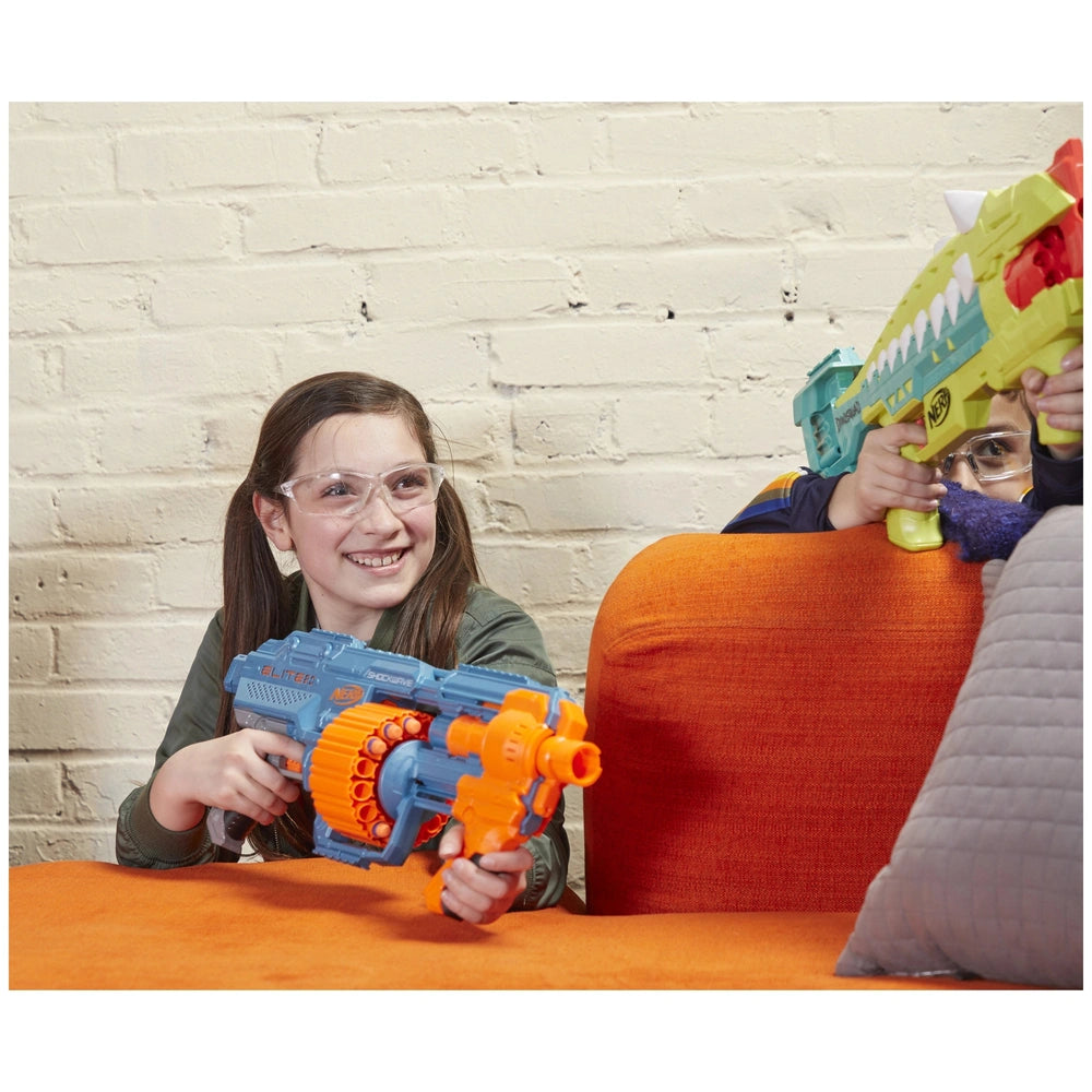 Nerf Elite 2.0 Shockwave RD-15 Blaster held by two kids on an orange couch against a white brick wall.