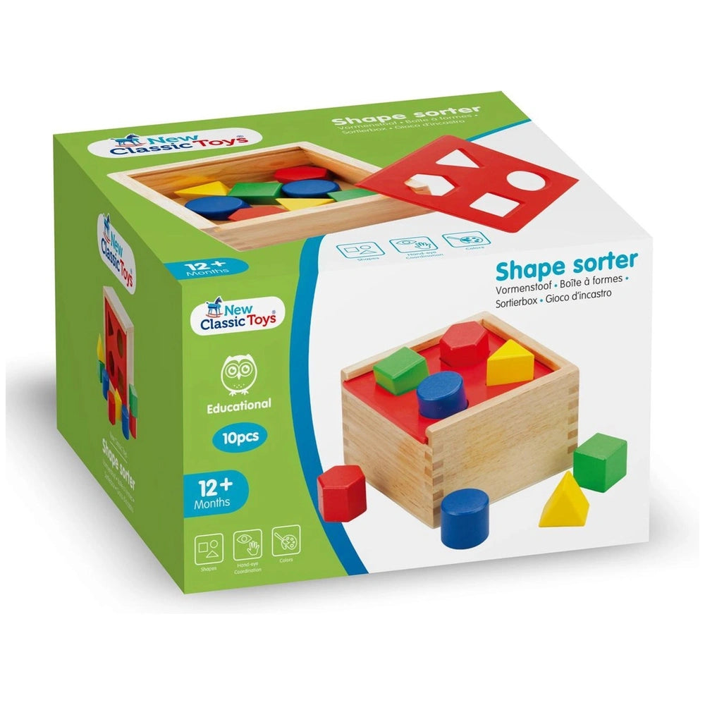Colorful shape sorter toy packaging features a green matte cardboard with a transparent window showcasing various red, yellow