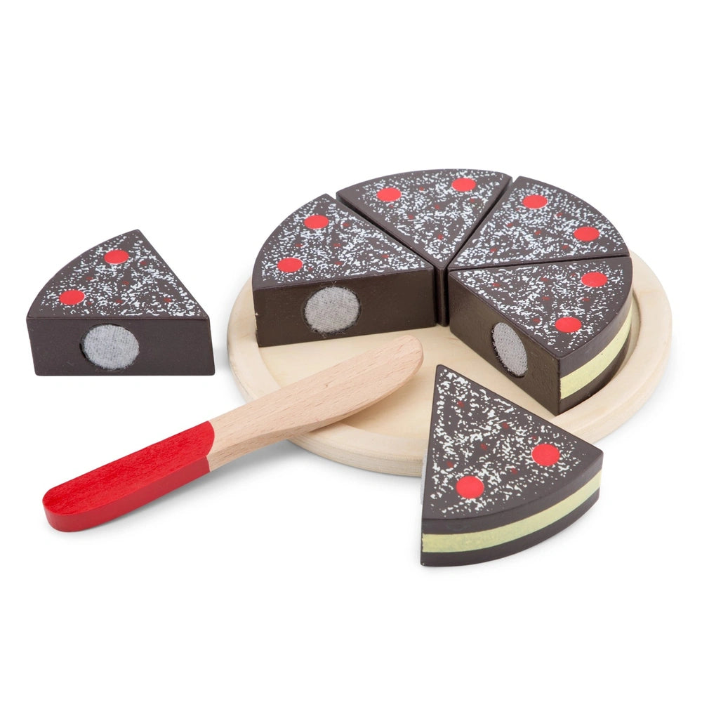 Chocolate crust pizza slice on a wooden spatula, decorated with red and white dots and a yellow stripe, on a white plate.