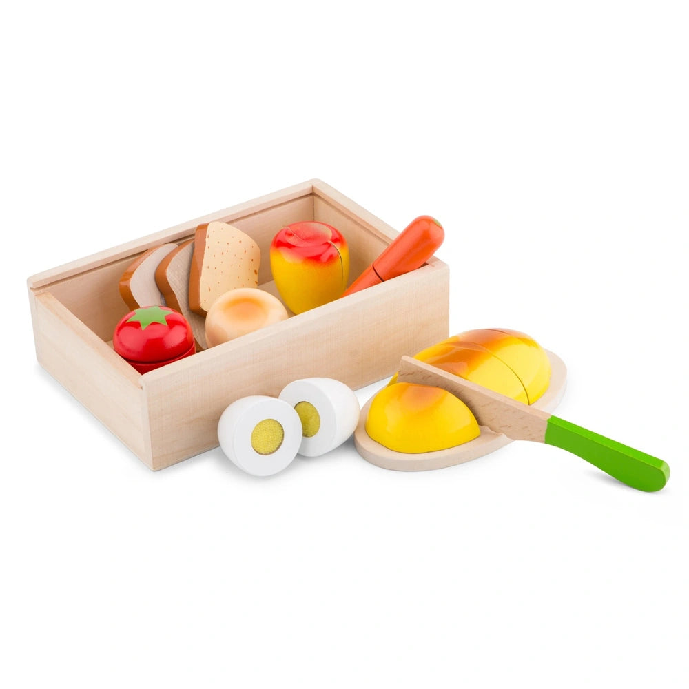 New Classic Toys Cuttingset features a wooden box filled with plastic food items including eggs, bread, tomato, hot dogs, and