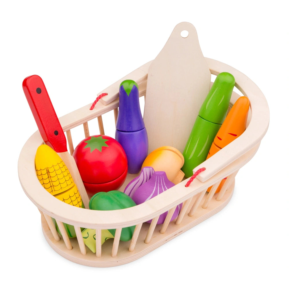 New Classic Toys vegetable basket set featuring various colorful plastic vegetables and a red plastic knife in a wooden baske