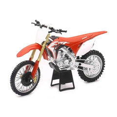 Red die-cast Japan dirt bike with white seat, black wheels, silver engine, and gold exhaust in a front view layout.