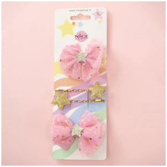 Classy ribbon hair clip set featuring two pink bows with gold stars on a matte cardboard packaging with a clear plastic windo