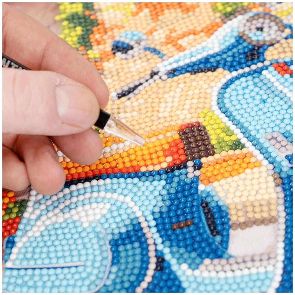 Diamantiny artist-level up painting on colorful beaded fabric, with a hand holding a black pen drawing on the textured surfac