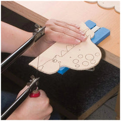 Hand sawing a wooden dinosaur shape using the PEBARO 915 Fretsaw set clamped to a table.