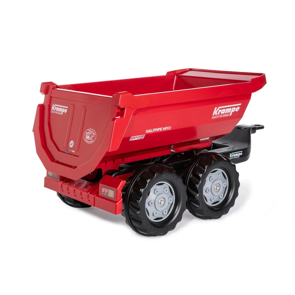 Red Rollyhalfpipe Krampe trailer toy tractor with black wheels and flat trailer, designed for carrying items securely.