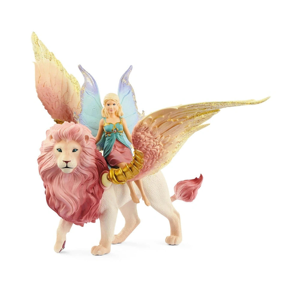 Schleich Bayala fairy figure in flight on a winged lion, featuring a pink mane, blue dress, and gold wings.
