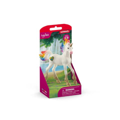 Schleich Rainbow Love Unicorn Foal figurine with rainbow mane, set against white packaging with pink and blue text.