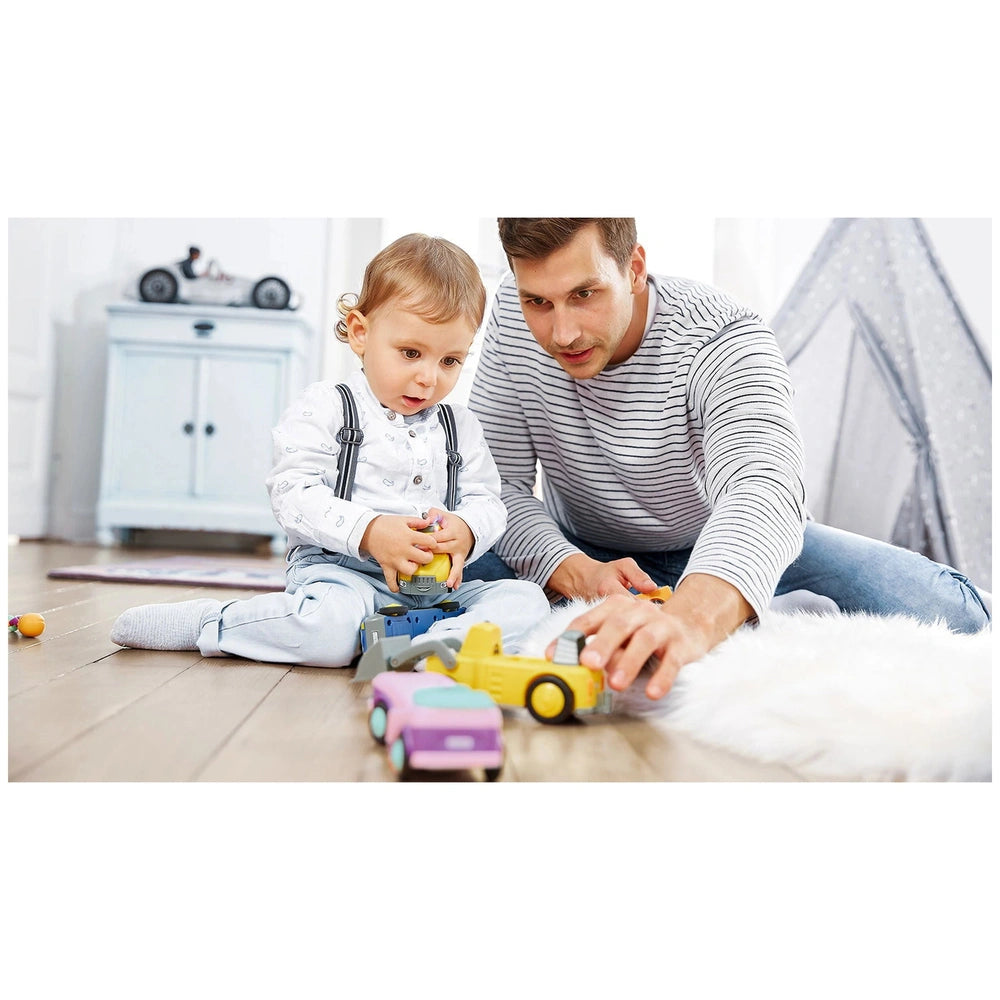 Siku - Betty Blinky - Toddy's construction set toys are being played with by a man and a child on a light hardwood floor.