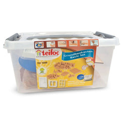 Teifoc basic construction kit in a clear plastic container filled with light-colored craft materials against a plain backgrou