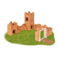 Teifoc castle made of brown bricks features a white archway, set on a natural green surface.